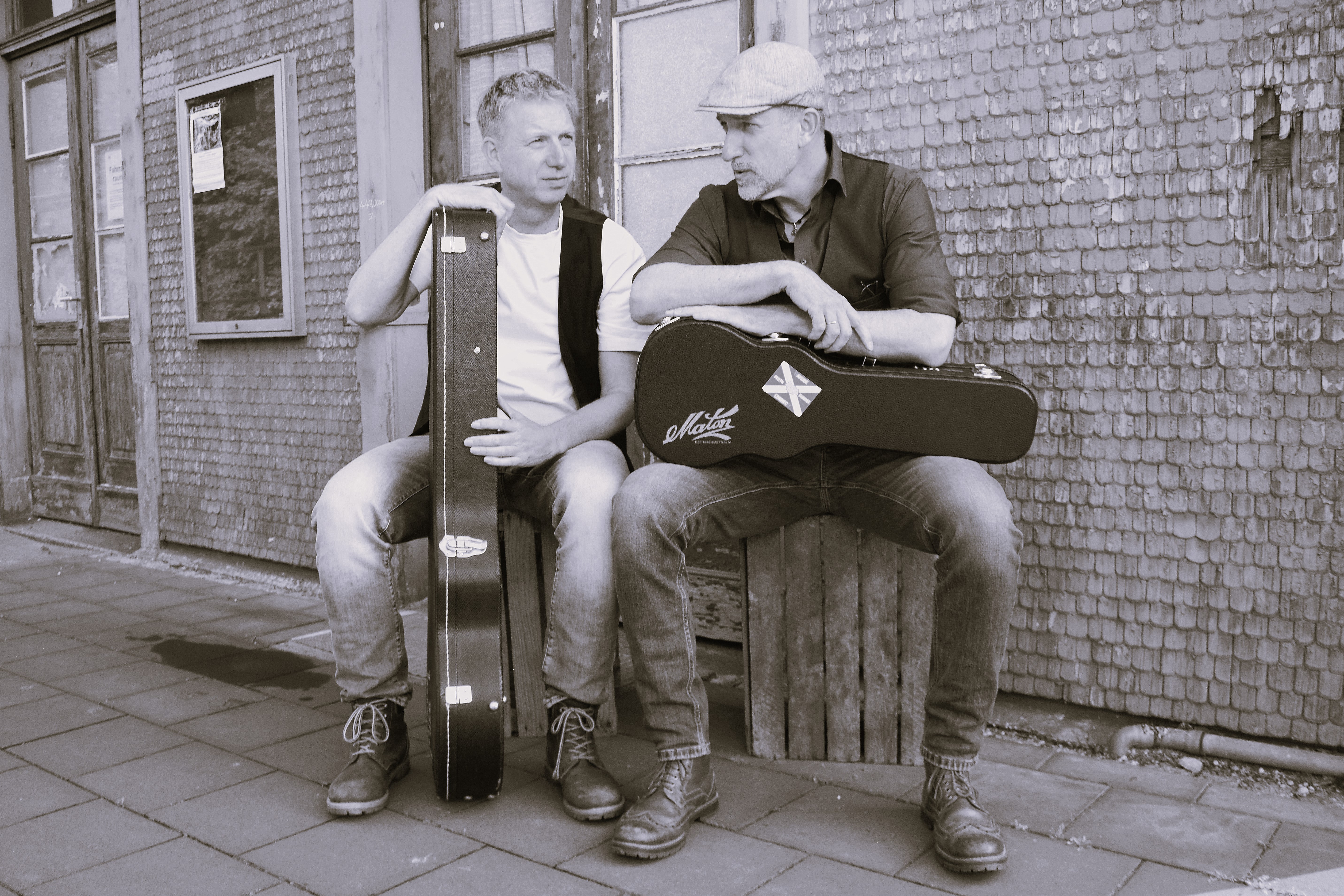 Schwarz-weiß Bild. Lothar Stadelmeier (links) mit Gitarre und Rik Schwarz (rechts) mit Ukulele